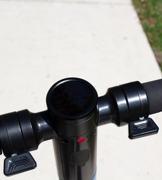 Regen Brake on Left, Throttle on Right, Dash in center, Red Power button, Charge port below.